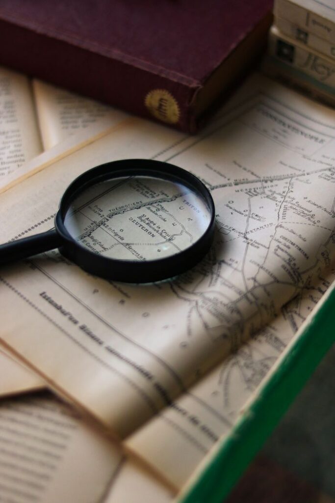 Explore vintage maps and books with a magnifying glass, evoking a sense of adventure and nostalgia.