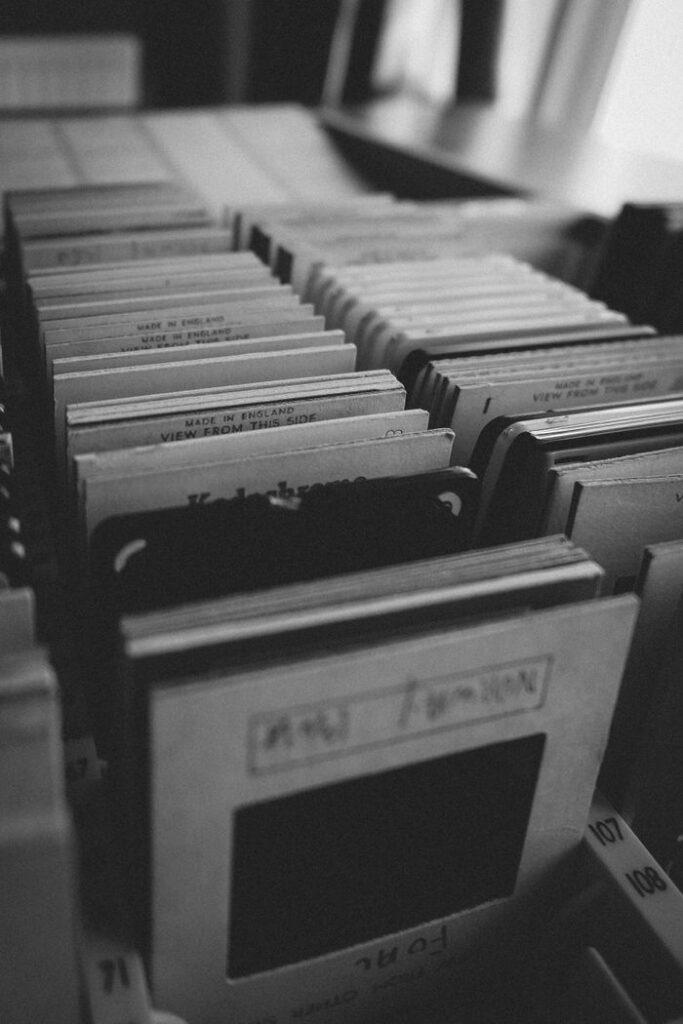 Close-up view of vintage photography slides organized in rows. Black and white tones.