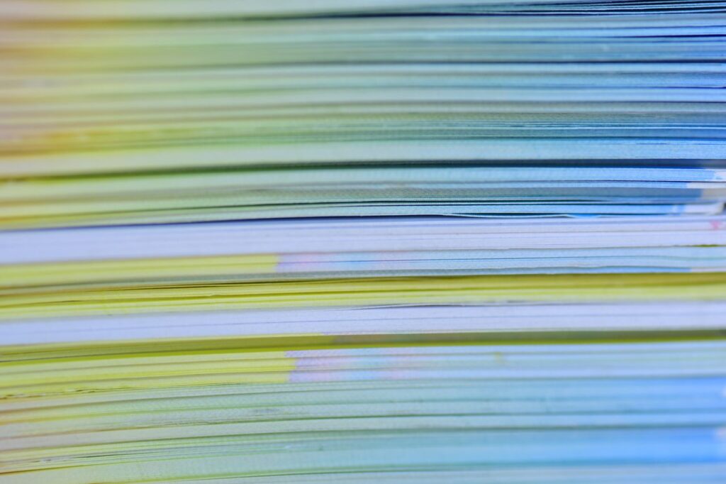 Close-up photo of a colorful stack of papers creating a vibrant abstract pattern.