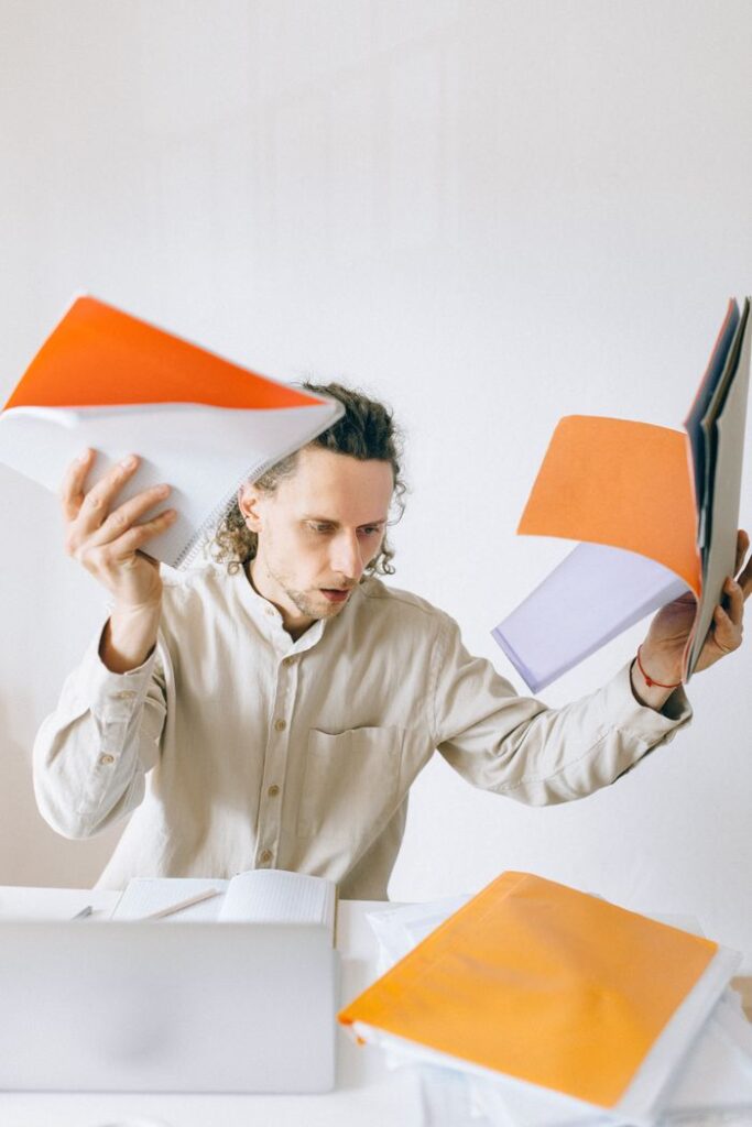 A stressed employee struggles with an overwhelming workload in the office.